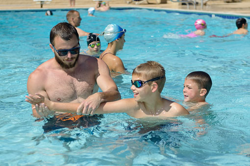 Coach Ryan helping kids at swim clinic
